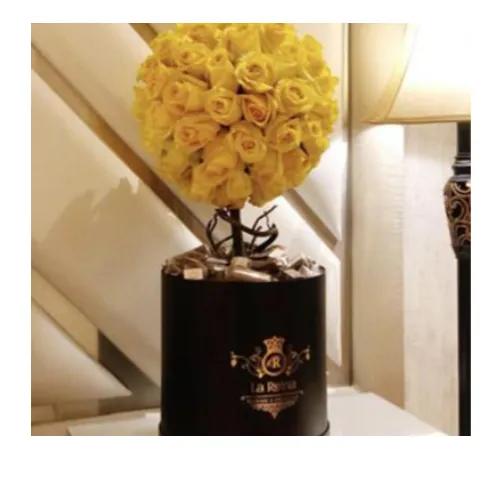 Round box with flower arrangement and chocolate