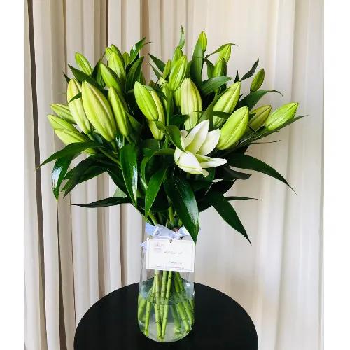 Vase transparent with lilies white arrangement