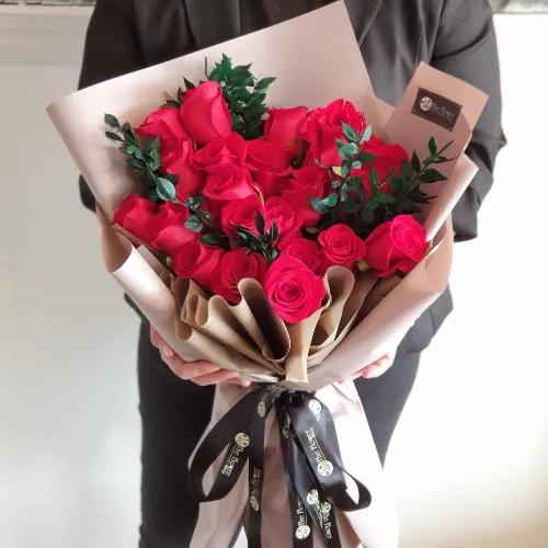 Hand Bouquet With Red Roses And Dried Leaves