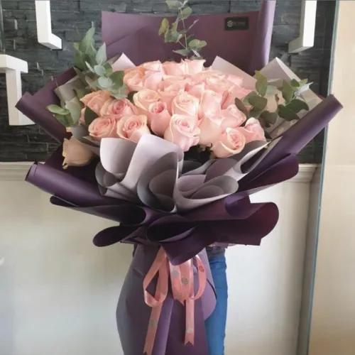 Hand Bouquet With Pink Roses And Green Leaves