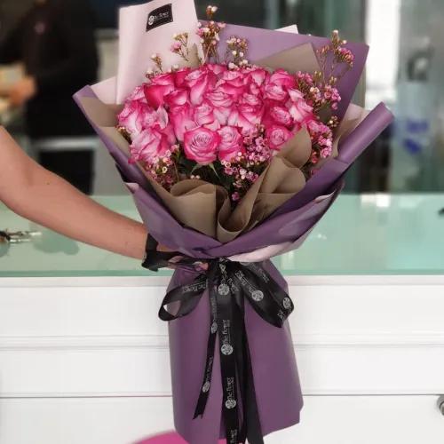 Hand Bouquet With Purple Roses And Waxflower