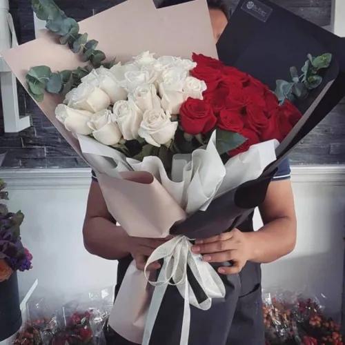 Hand Bouquet With Red And White Roses In Black And Nude Paper Wrapping