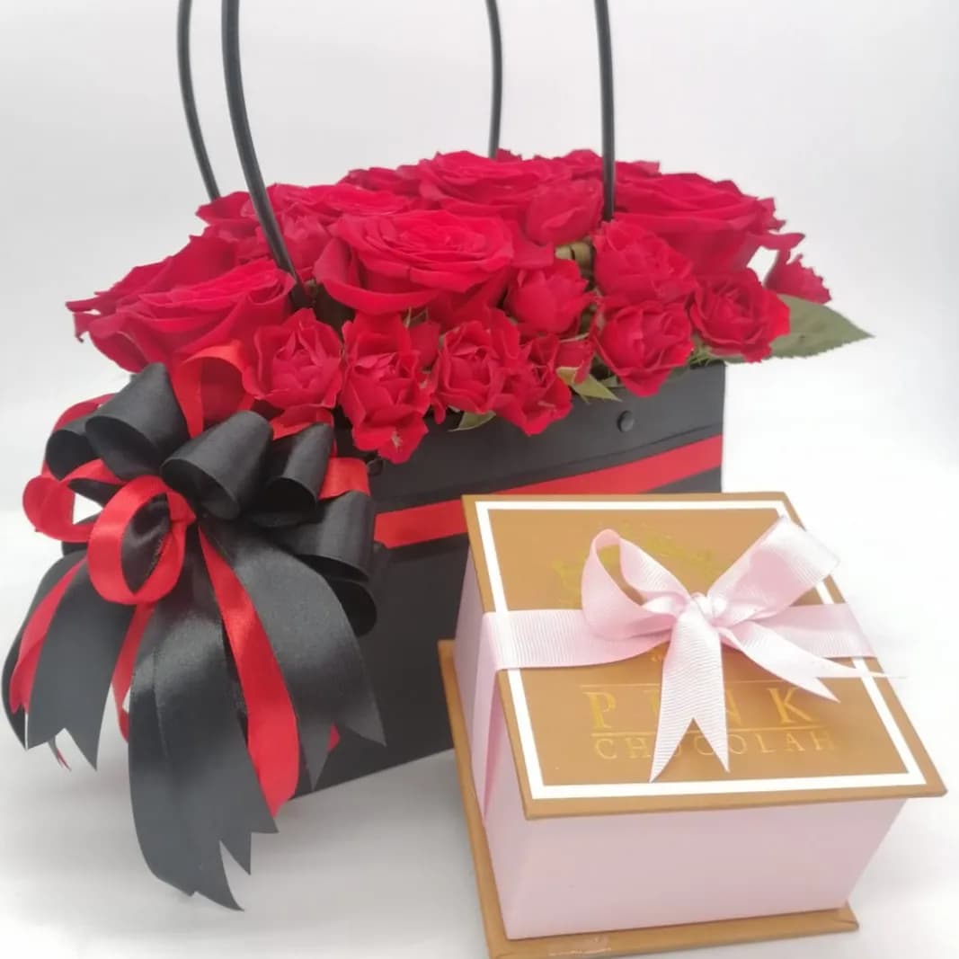 A Black Bag With Mix Natural Flowers With A Box Of Mix Chocolates
