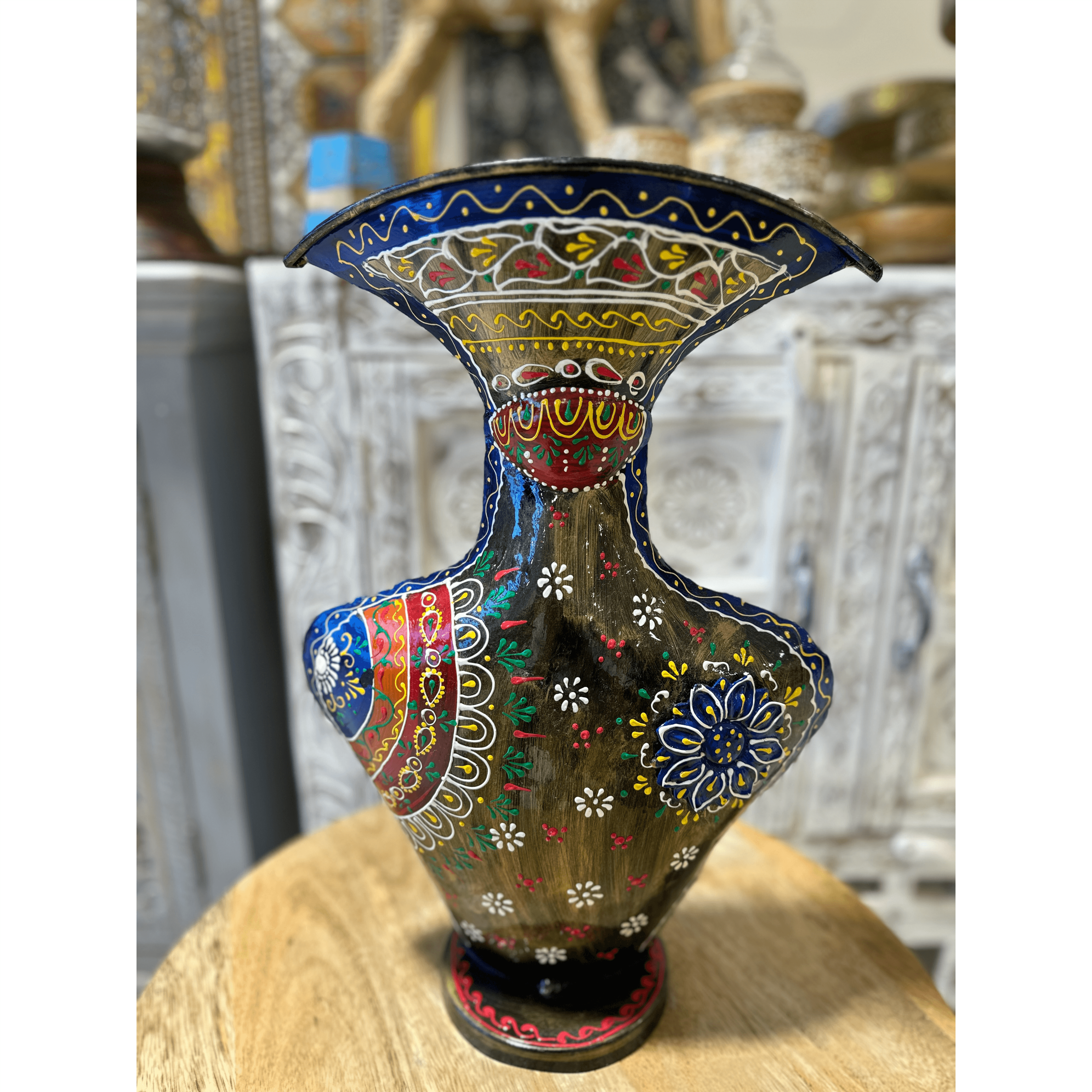 Metal vase with hand-drawn designs.