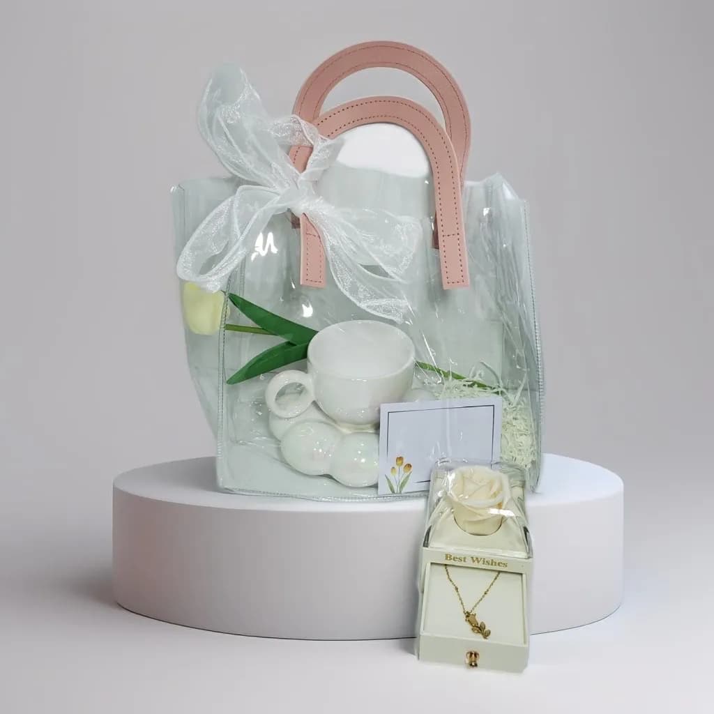 Gift giving: a white flower ceramic cup, a white tulip rose, an acrylic box with a white flower with a gold-plated tulip flower Necklace  inside.