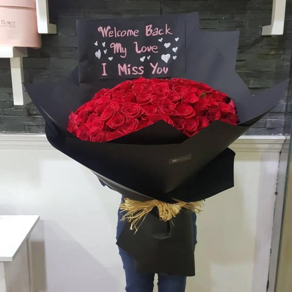 Hand Bouquet With Red Roses In Black Paper Wrapping